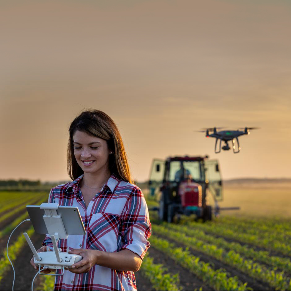 Vrouw houdt controller van drone vast op een akker