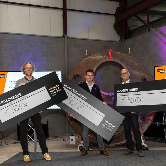 3 mannen op een podium met grote waardechecques ter waarde van € 50.000